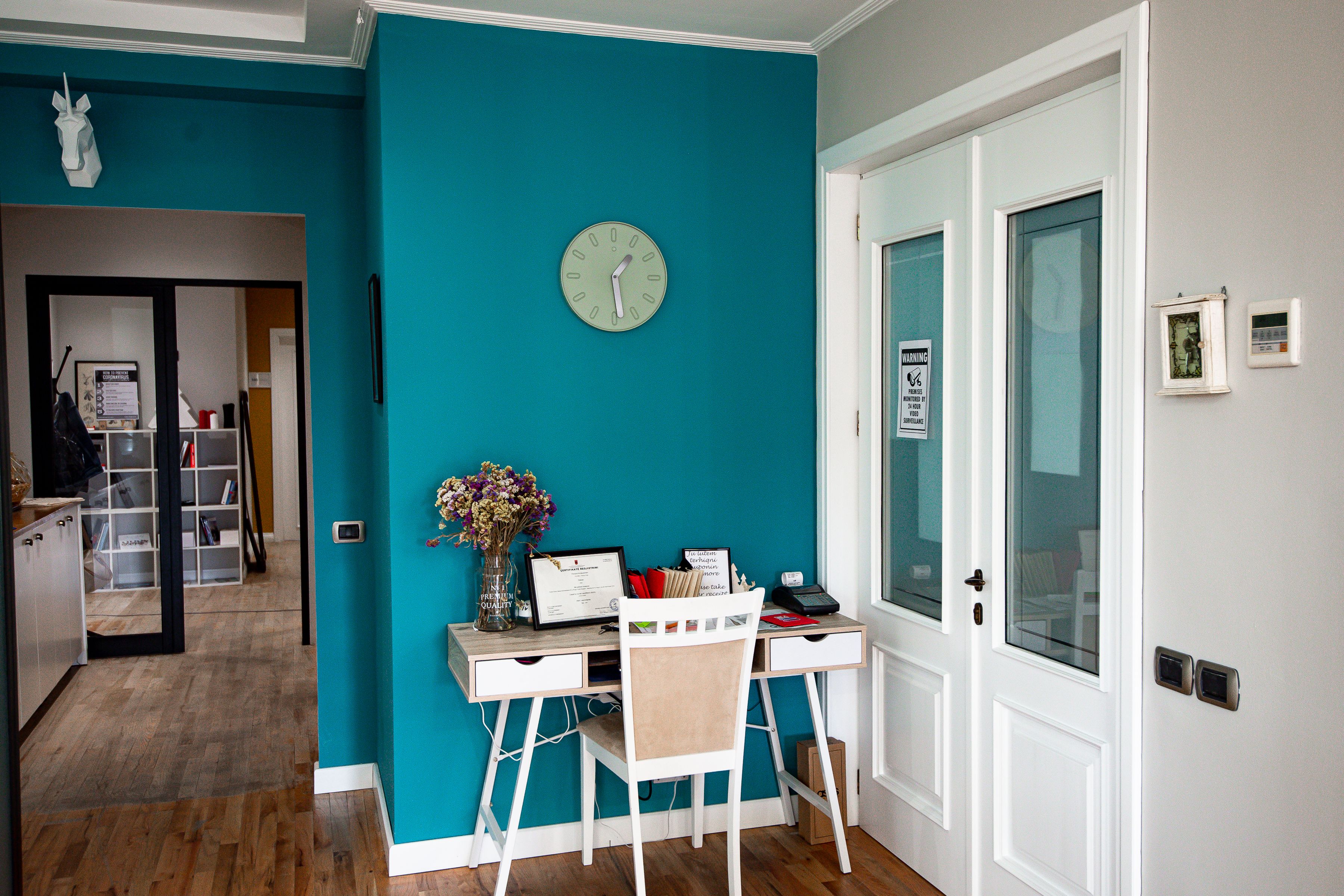 A desk by the teal wall in the Innospace Tirana coworking space